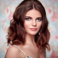 Portrait of young beautiful woman on a background of flowers. Fashion photo. Jewelry and hairstyle. Perfect makeup